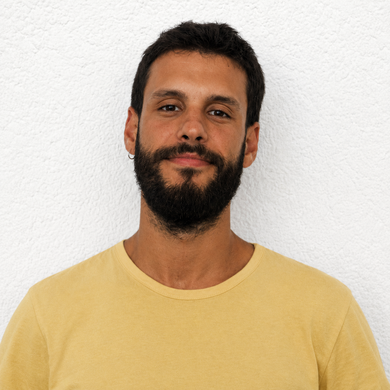 Retrato de Nicolás Hernández con camiseta amarilla sobre fondo claro